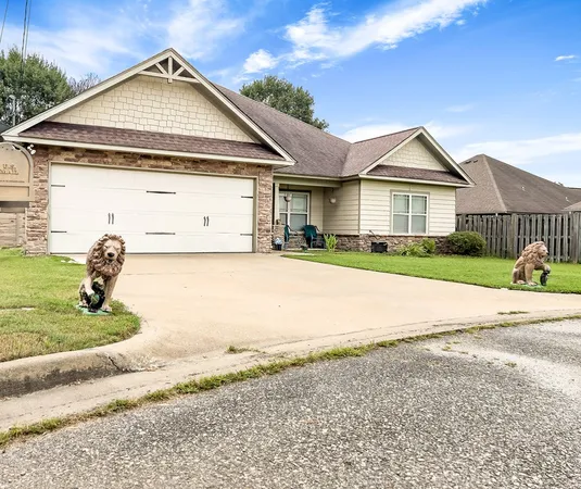 a view of a house with a yard and large tree