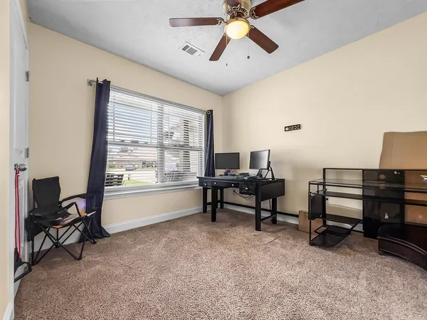 a view of a workspace with furniture and a window