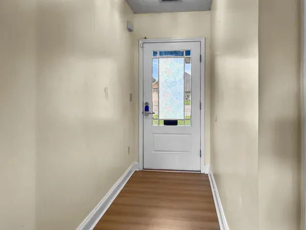 a view of a hallway with wooden floor