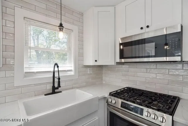 a kitchen with granite countertop a stove and a sink