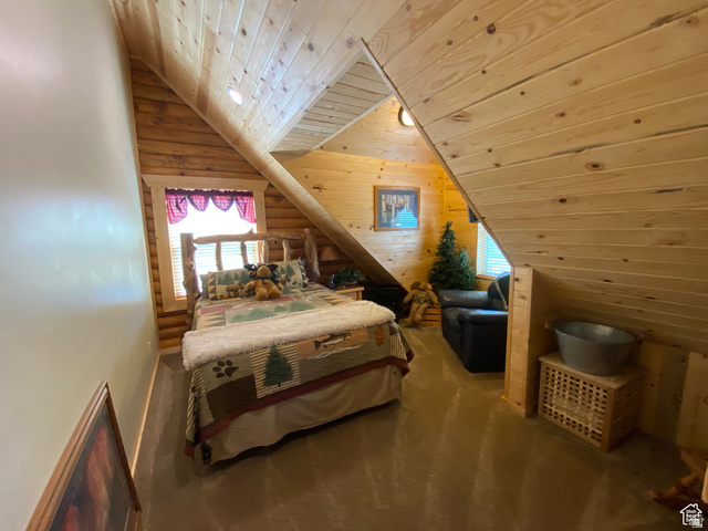 79 Auburn Forest Road Auburn, WY 83111 - Photo 46 of 76 Bedroom featuring a vaulted wood ceiling, carpet, multiple windows, wooden walls, and rustic walls