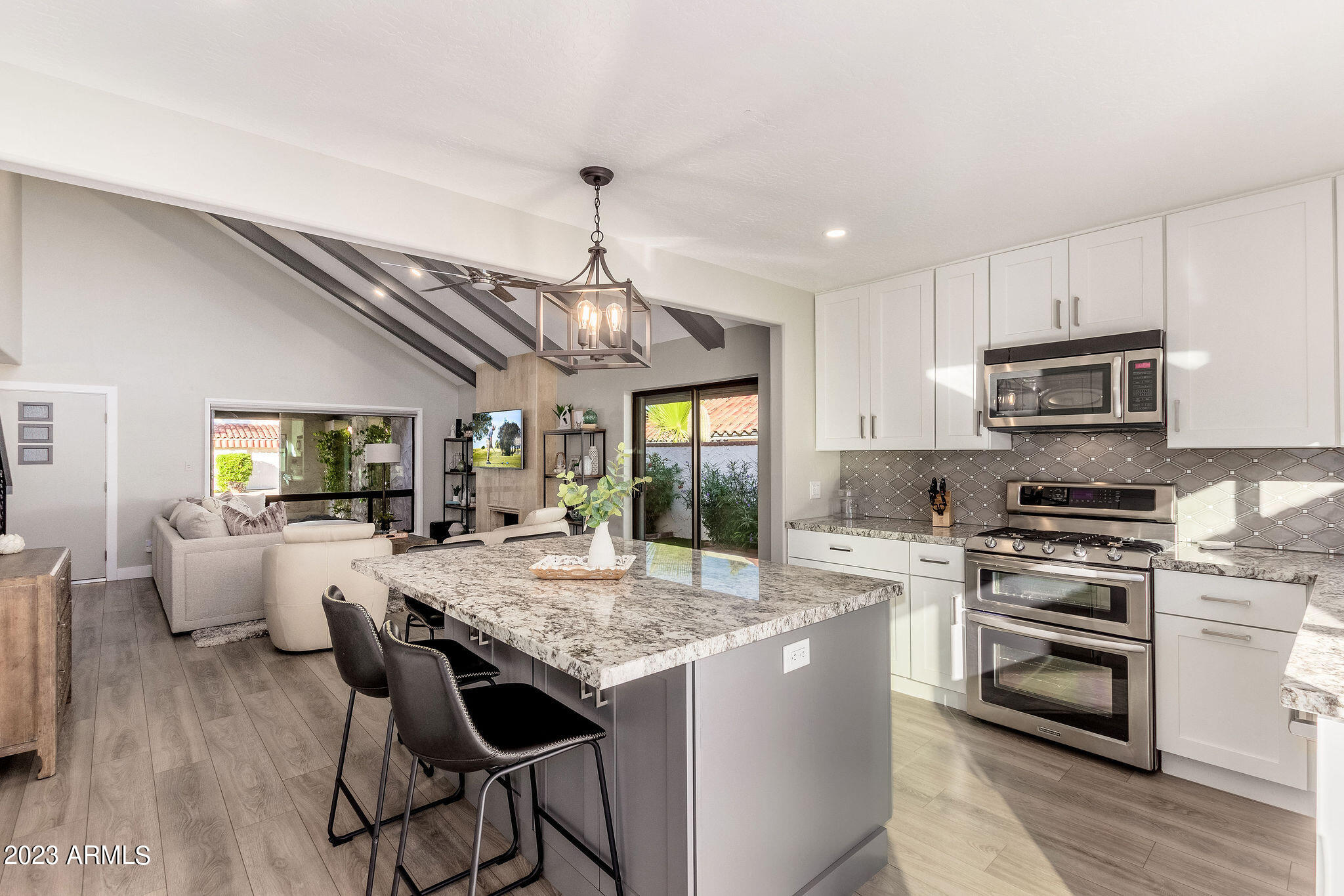 5822 North Scottsdale Road Paradise Valley, AZ 85253 - Photo 7 of 31 a large kitchen with granite countertop a stove a sink a dining table and chairs