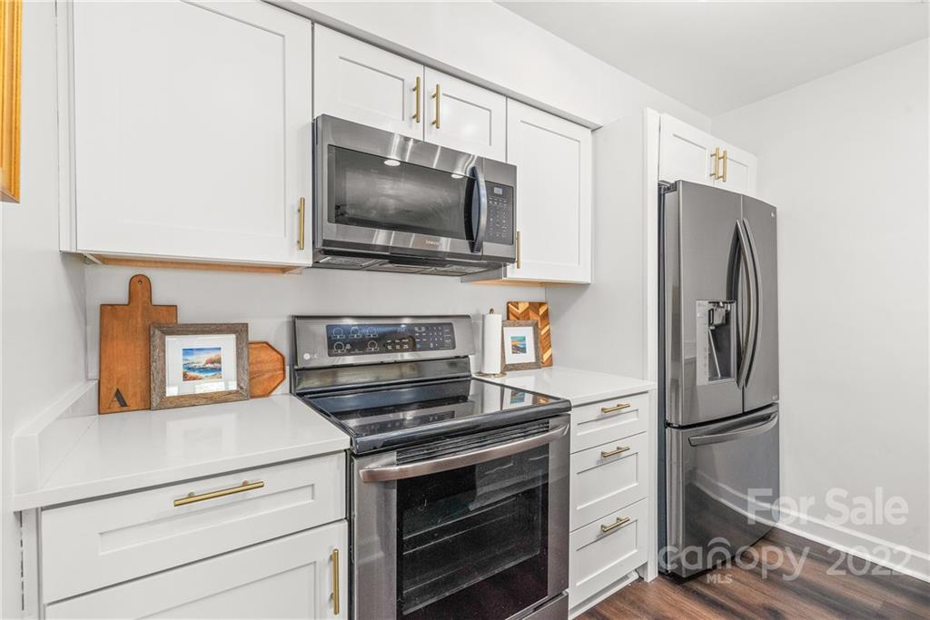318 Queens Road, Unit 2 Charlotte, NC 28204 - Photo 4 of 18 a kitchen with stainless steel appliances white cabinets and a stove top oven