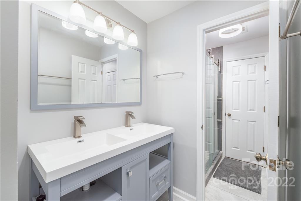 318 Queens Road, Unit 2 Charlotte, NC 28204 - Photo 6 of 18 a bathroom with a sink a mirror and a vanity