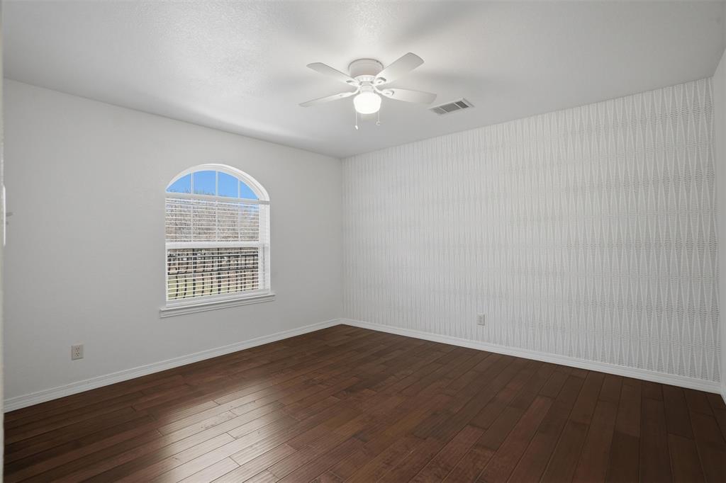 9651 Yellow Rose Lane Pilot Point, TX 76258 - Photo 29 of 38 an empty room with wooden floor chandelier fan and windows