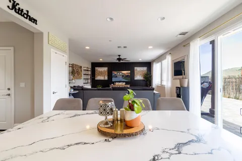 a living room with furniture kitchen and a chandelier