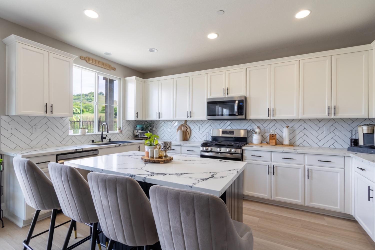 9419 Vintner Circle Patterson, CA 95363 - Photo 16 of 34 a kitchen with stainless steel appliances granite countertop a stove a sink dishwasher a microwave oven and a refrigerator with wooden cabinets