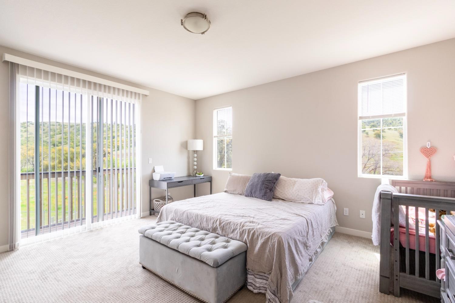 9419 Vintner Circle Patterson, CA 95363 - Photo 18 of 34 a bedroom with a bed and a large window