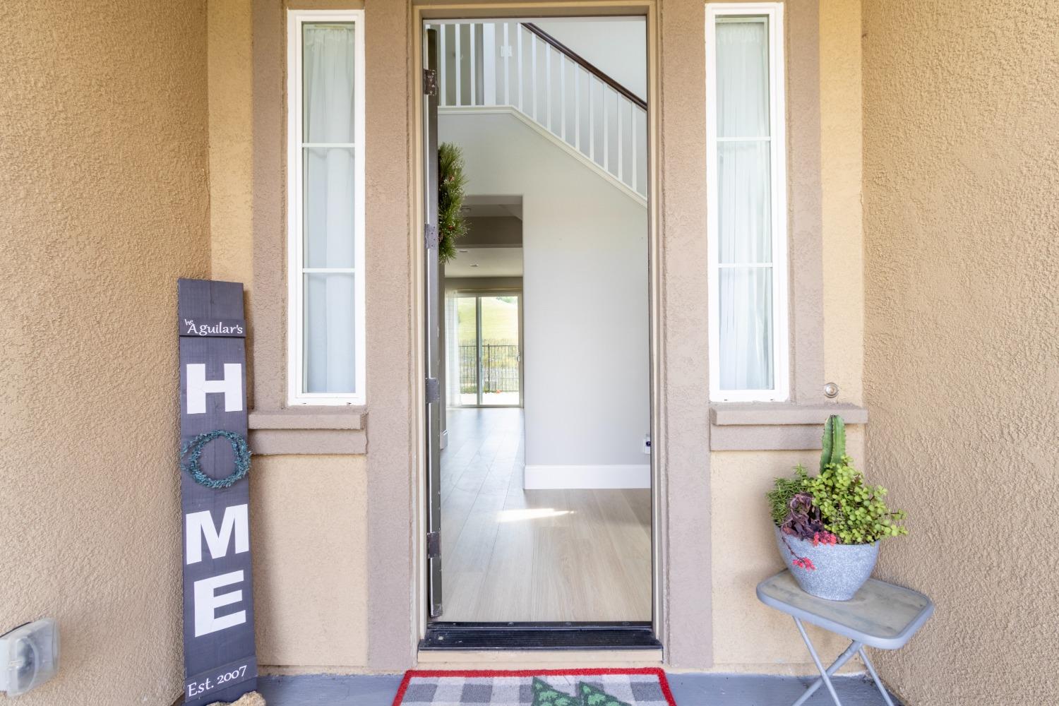 9419 Vintner Circle Patterson, CA 95363 - Photo 6 of 34 a view of an entryway with wooden floor and a potted plant