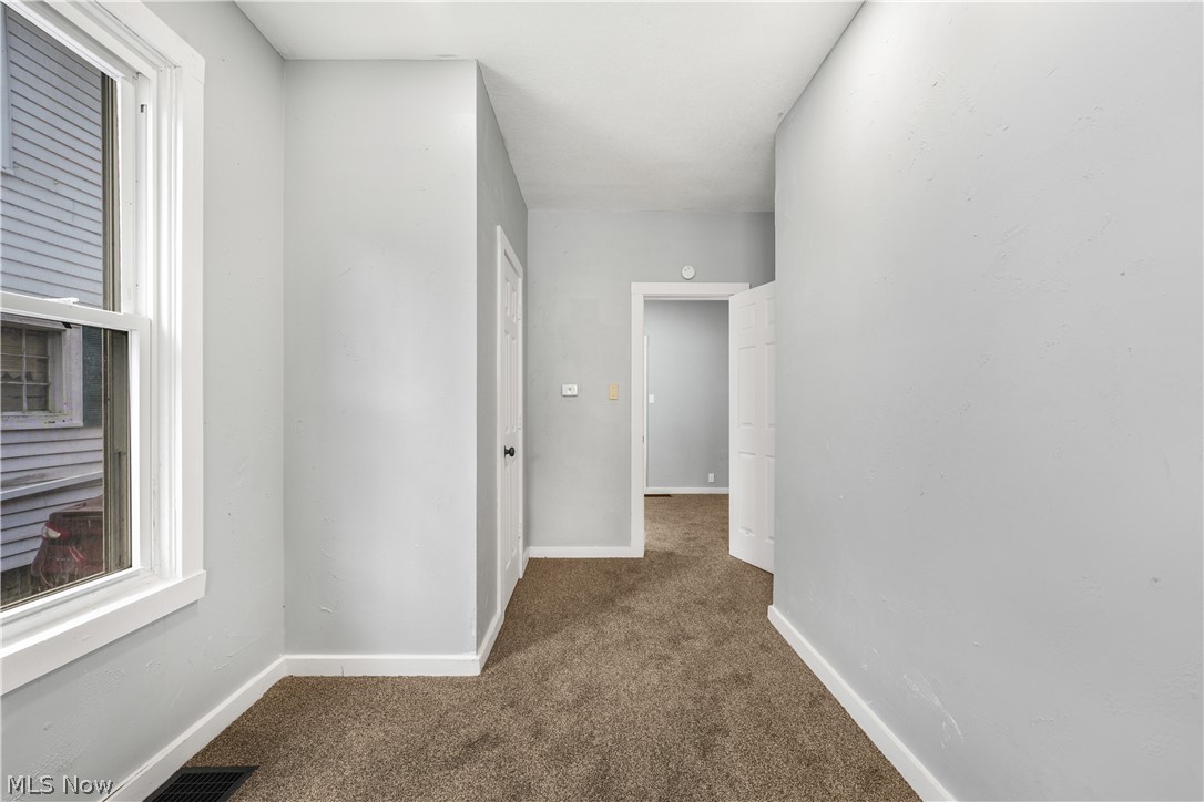 885 Wales Road Northeast Massillon, OH 44646 - Photo 6 of 34 Hallway featuring neutral-toned carpet flooring and light gray painted walls