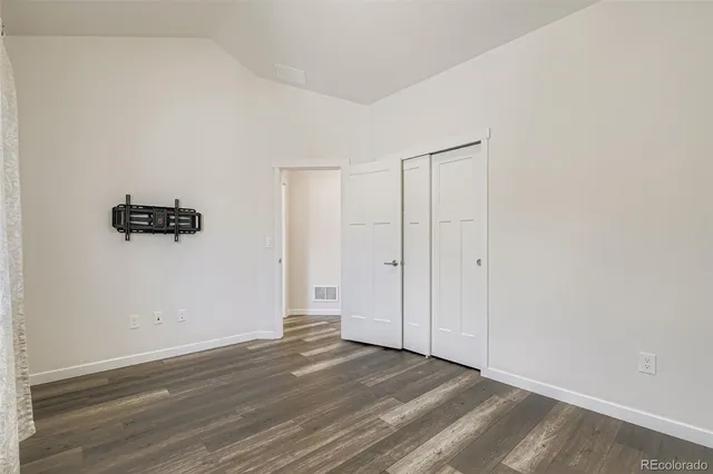 a view of a room with wooden floor and a ceiling fan