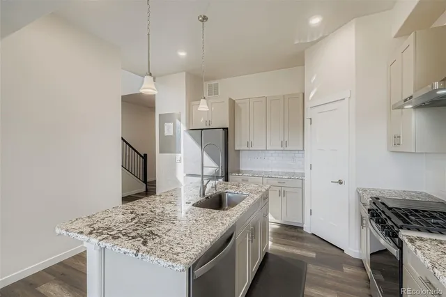 a kitchen with stainless steel appliances granite countertop a sink stove and refrigerator