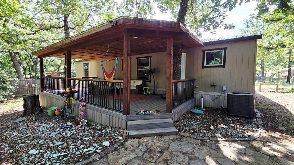45 Bravo Road Pottsboro, TX 75076 - Photo 39 of 40 Covered porch with exposed wood beams, composite decking, and black metal railings