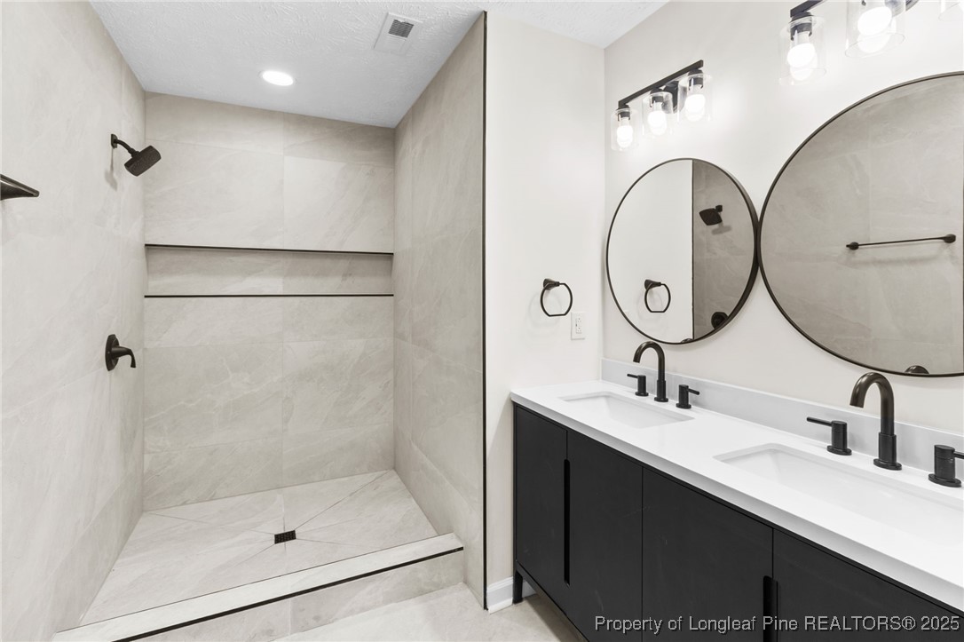 5520 Rising Ridge Drive Hope Mills, NC 28348 - Photo 11 of 30 a bathroom with a sink a shower and a mirror
