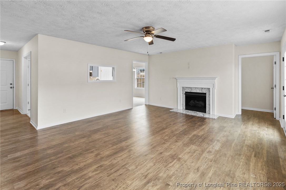 5520 Rising Ridge Drive Hope Mills, NC 28348 - Photo 4 of 30 a view of an empty room with wooden floor fireplace and a window