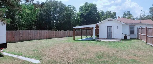 a view of a backyard with a house and a large tree