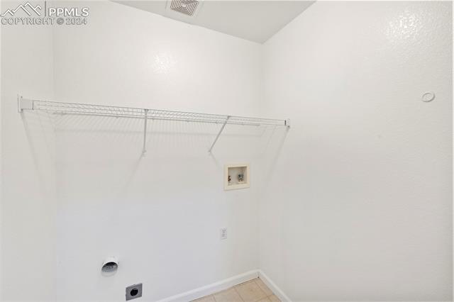 6725 Akron Road Colorado Springs, CO 80923 - Photo 33 of 50 Washroom with light tile patterned floors, hookup for an electric dryer, and washer hookup