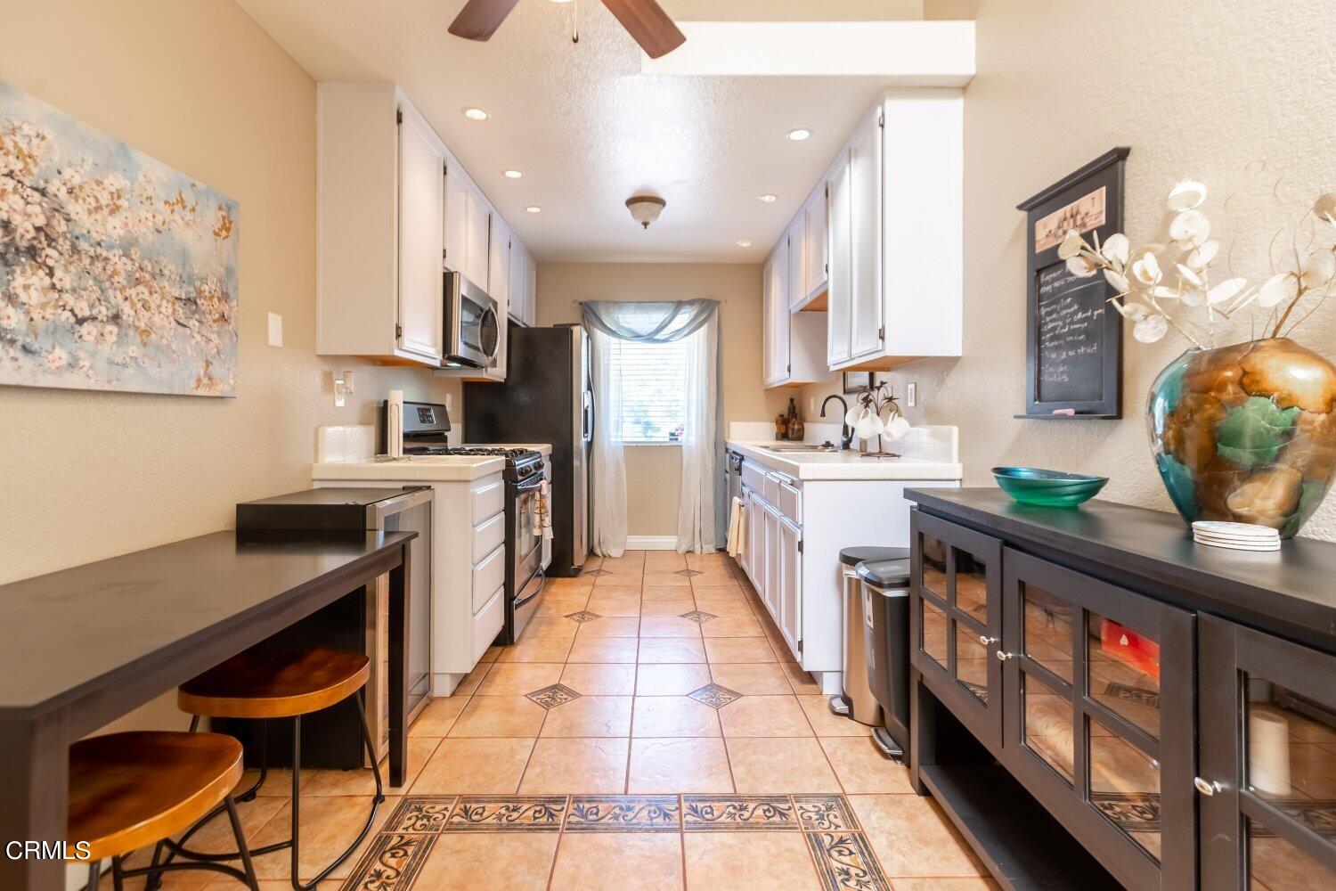 a kitchen with stainless steel appliances granite countertop a sink and a refrigerator
