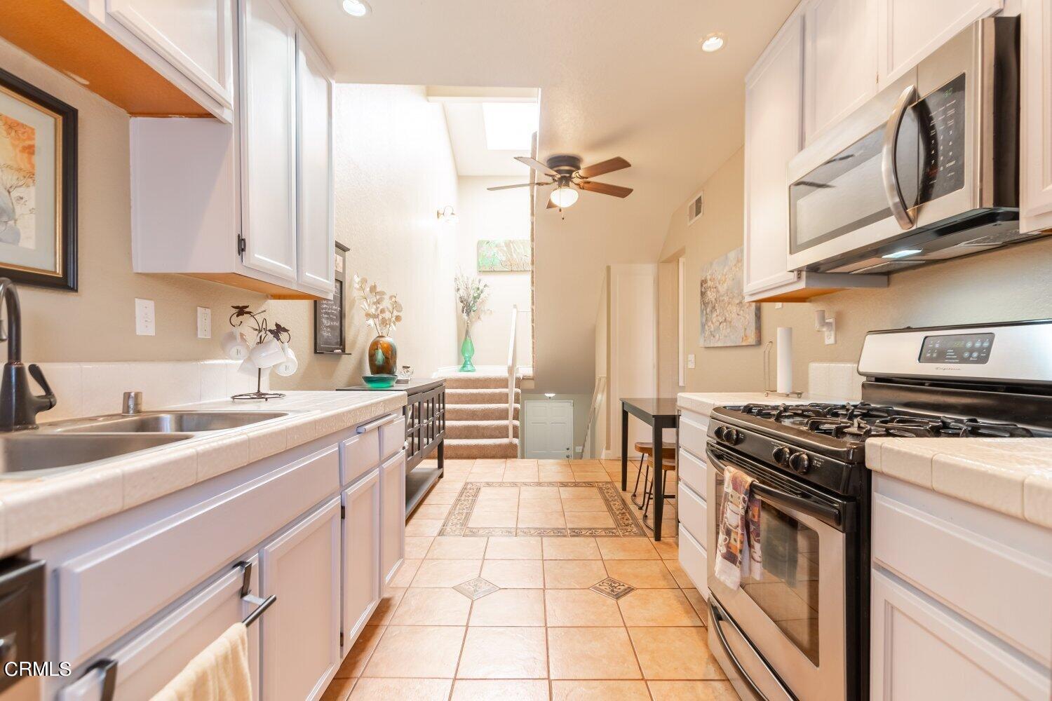 5204 Columbus Place Oxnard, CA 93033 - Photo 2 of 9 a kitchen with stainless steel appliances granite countertop a stove a sink and a microwave