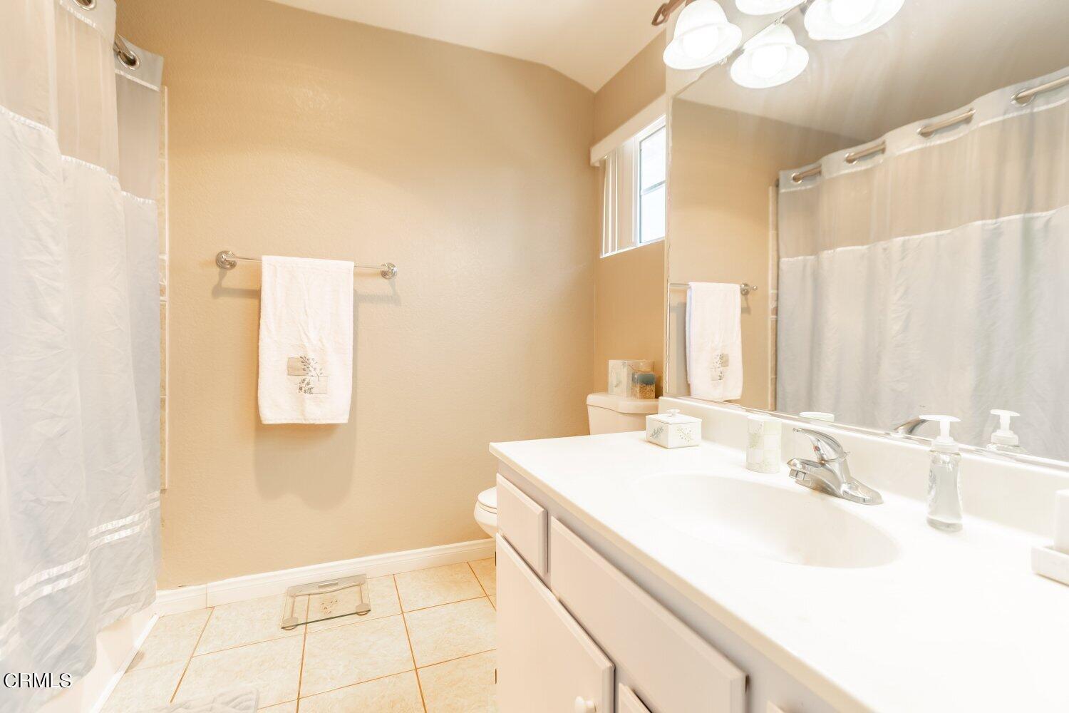 5204 Columbus Place Oxnard, CA 93033 - Photo 5 of 9 a bathroom with a sink a vanity and a mirror