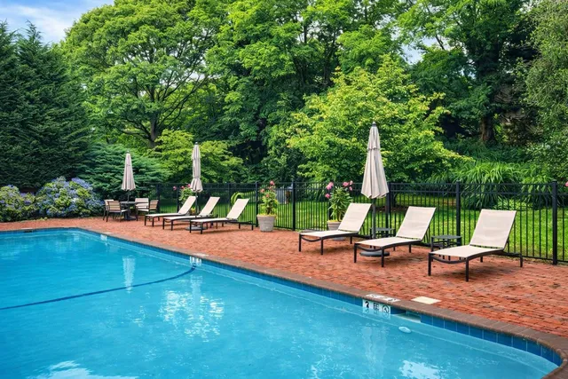 a view of a swimming pool with lounge chairs in patio