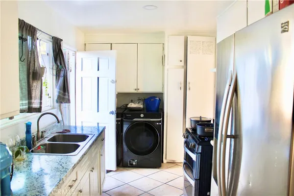a kitchen with stainless steel appliances granite countertop a refrigerator and a sink
