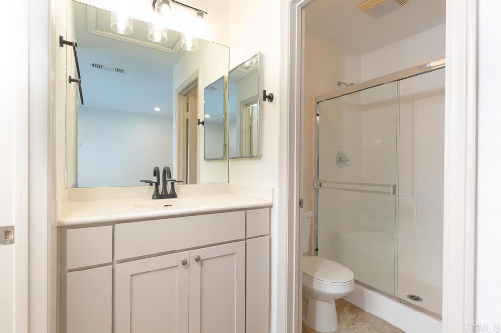 505 San Pasqual Valley Road, Unit 186 Escondido, CA 92025 - Photo 11 of 28 a bathroom with a sink a toilet a shower and a mirror