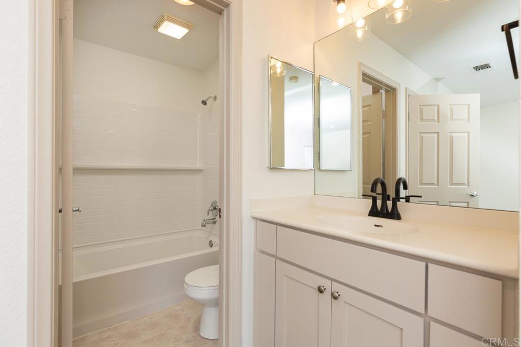 505 San Pasqual Valley Road, Unit 186 Escondido, CA 92025 - Photo 17 of 28 a bathroom with a sink a toilet and a large mirror