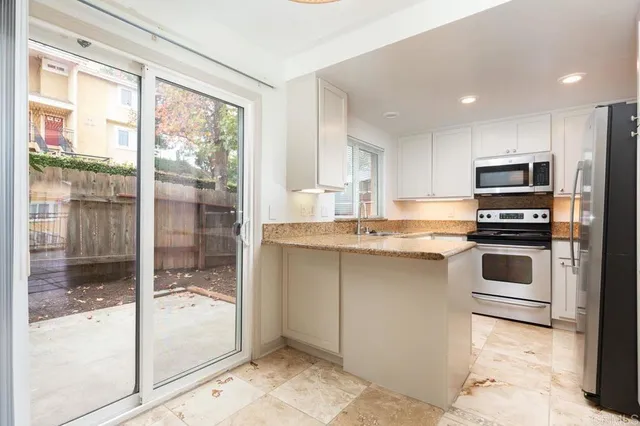 a kitchen with white cabinets and white appliances