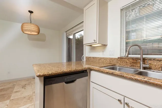 a kitchen with granite countertop a sink and a window
