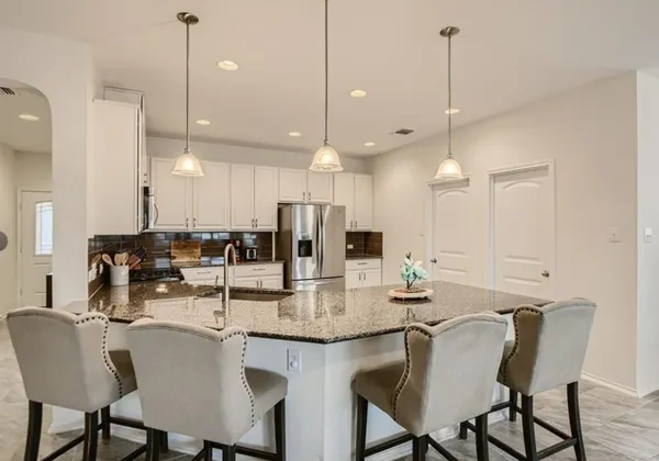 a kitchen with a dining table chairs and cabinets