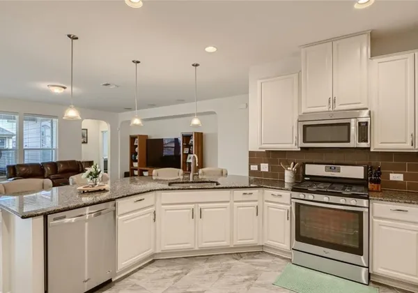 a kitchen with a sink stove and microwave