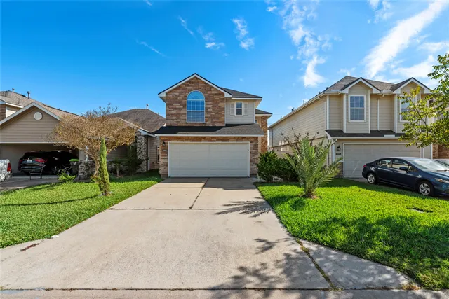 a front view of a house with a yard and garage