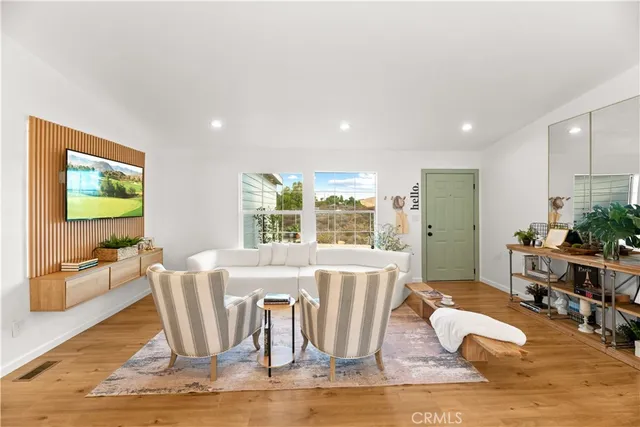 a living room with furniture wooden floor and a large window