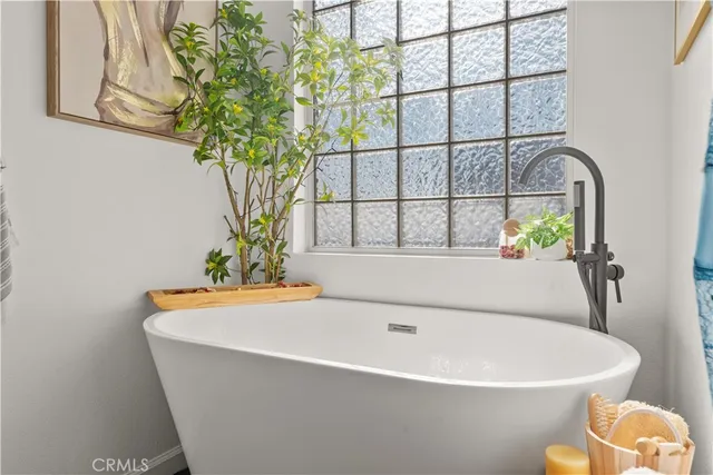 a white bath tub sitting in a bathroom next to a window