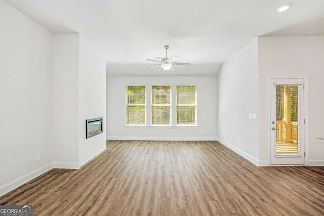 a view of kitchen with kitchen island wooden floor granite counter tops and white cabinets
