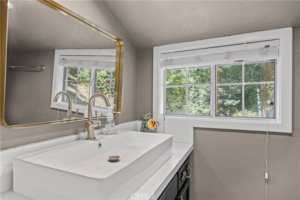 1139 Bear Springs Road Twin Peaks, CA 92391 - Photo 12 of 45 a bathroom with a sink and a large mirror