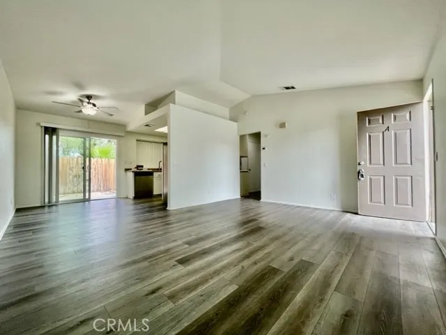 a view of an empty room with window and wooden floor