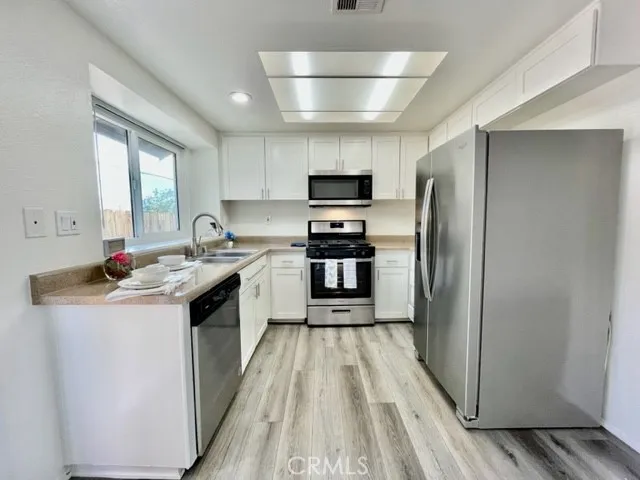 a kitchen with kitchen island a sink appliances and cabinets