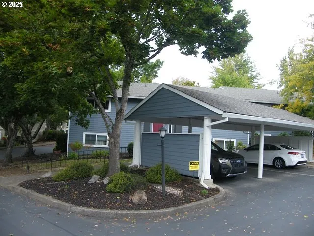 a front view of a house with cars parked