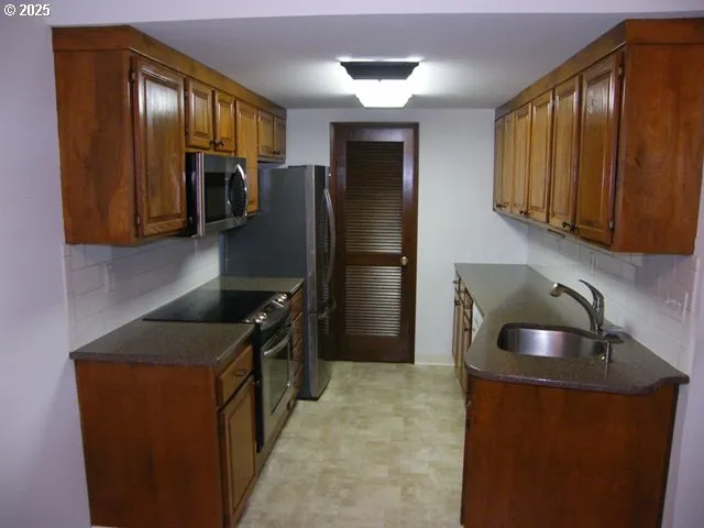 a kitchen with stainless steel appliances granite countertop a refrigerator and a sink