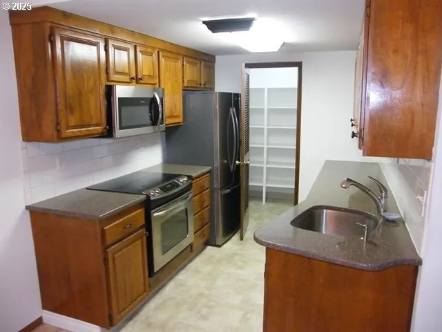 a kitchen with granite countertop a sink stove and refrigerator