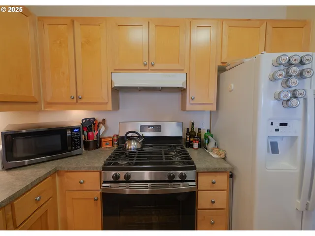 a kitchen with granite countertop cabinets and steel stainless steel appliances