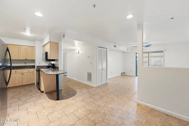 a kitchen with stainless steel appliances kitchen island granite countertop a refrigerator and a stove top oven