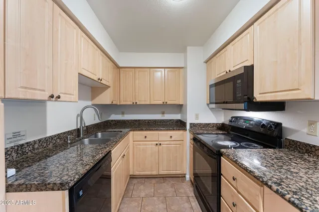 a kitchen with stainless steel appliances granite countertop a sink stove and microwave