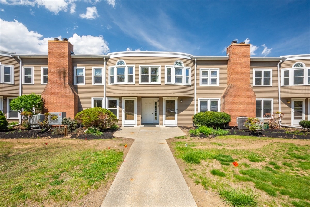 a front view of a residential apartment building with a yard