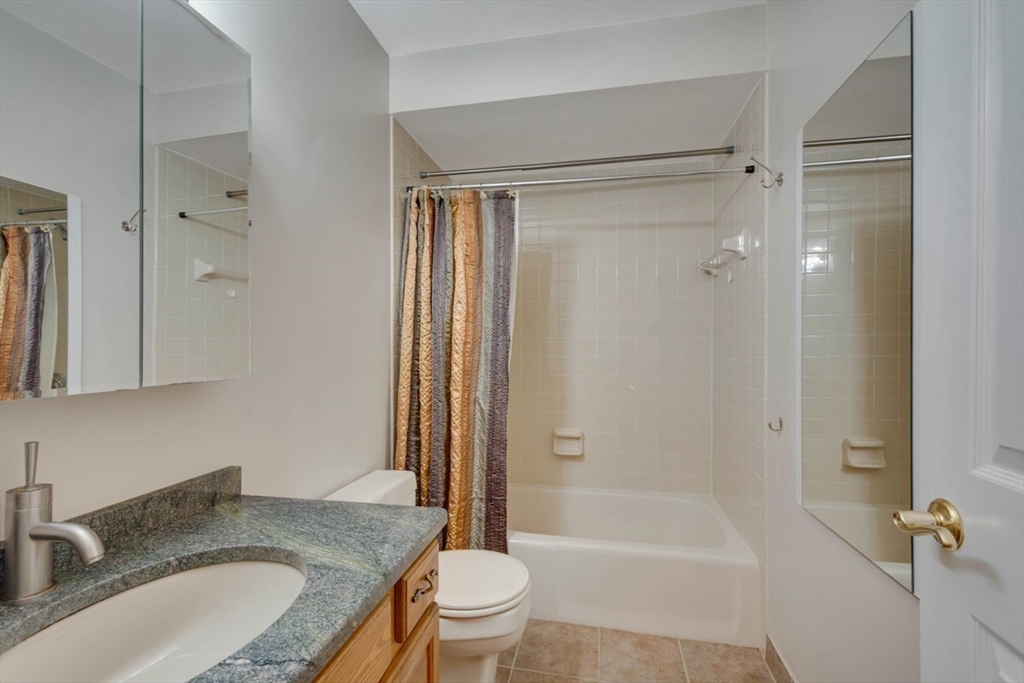 75 Page Road, Unit 16 Bedford, MA 01730 - Photo 19 of 27 a bathroom with a granite countertop sink toilet and shower