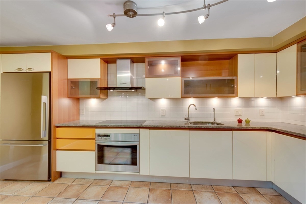 75 Page Road, Unit 16 Bedford, MA 01730 - Photo 8 of 27 a kitchen with stainless steel appliances granite countertop a sink and a refrigerator
