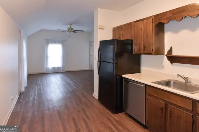 a kitchen with wooden floors a refrigerator and a sink