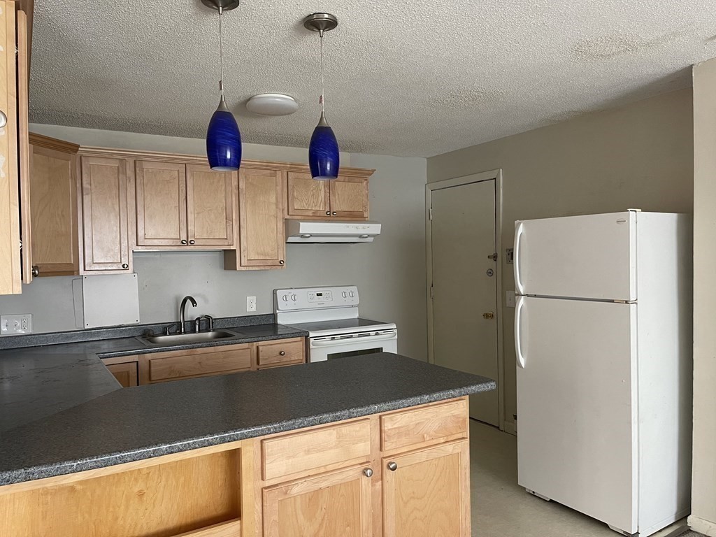 5 Turnpike Road, Unit 229 Townsend, MA 01469 - Photo 3 of 13 a kitchen with stainless steel appliances granite countertop a sink a refrigerator a stove and white cabinets